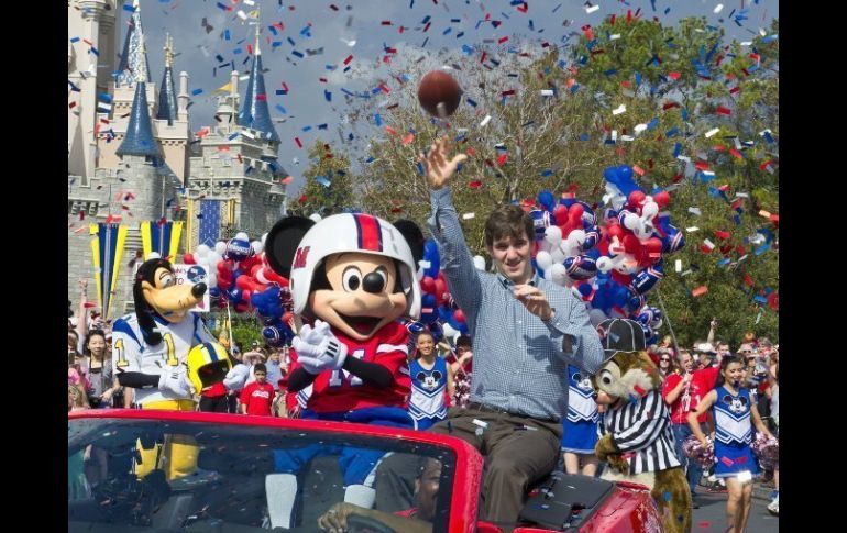 El quarterback de Gigantes, Eli Manning, saluda hoy en un desfile con personajes de Disney por el triunfo en el Super Bowl. EFE  /