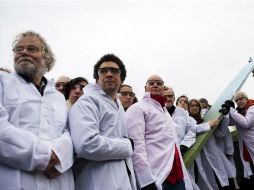 Activistas vestidos como científicos protestan contra el informe sobre calentamiento global. AFP /