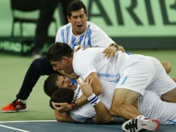 Federico Delbonis (segundo de abajo hacia arriba) celebra la victoria con sus compañeros de equipo. AP / D. Vojinovic