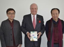 El embajador Jorge Heine (c); el hispanista Wen Ran (i), y el profesor universitario y traductor Zhao Zhenjian, posan hoy con el libro. EFE / R. Cañas