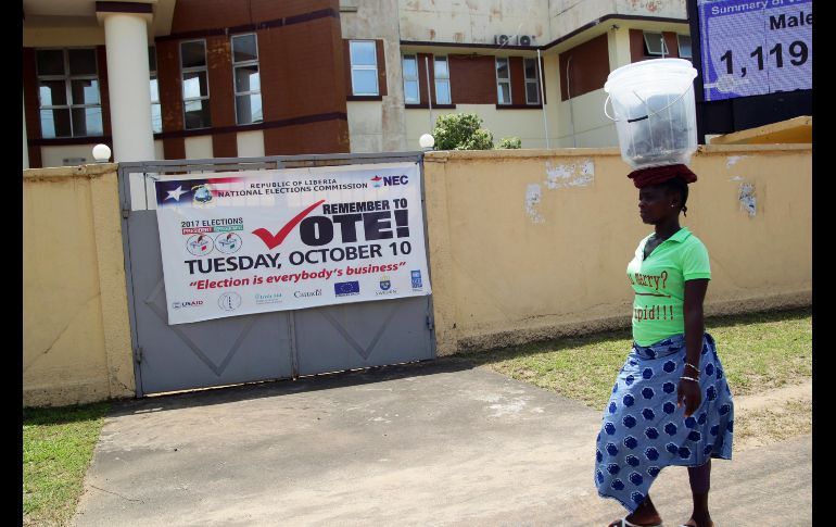 Una mujer pasa frente a una pancarta donde se lee 