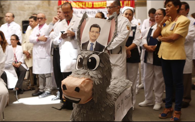 Médicos exhiben una piñata de asno con la leyenda 