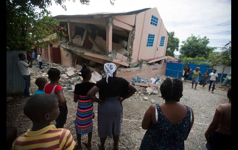 Habitantes miran una escuela dañada por el temblor en Gros Morne.