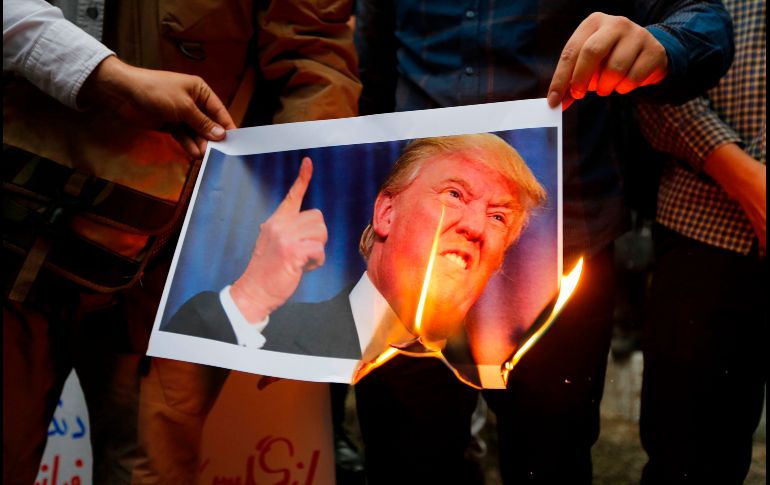 Iraníes queman una imagen de Donald Trump en una protesta afuera de la ex Embajada estadounidense en Teherán, el 9 de mayo, en respuesta a la salida de Estados Unidos del acuerdo nuclear con Irán. AFP/A. Kenare