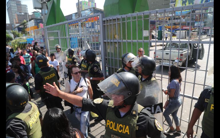 Miembros de la Policía peruana montan guardia en un ingreso cerrado al emporio comercial de Gamarra, en Lima. Gamarra, el mayor distrito comercial de Perú y el corazón de la industria textil del país, fue clausurado en la madrugada de este lunes mientras se desarrolla un operativo para combatir la informalidad. EFE/E. Arias