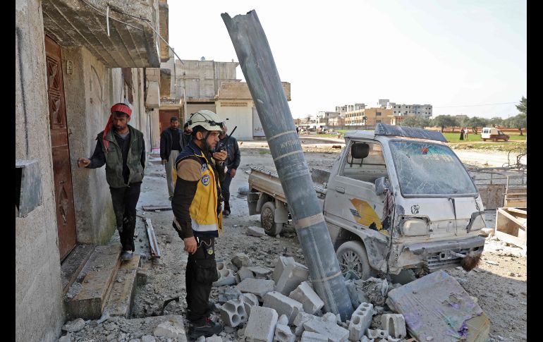 Sirios se paran junto a un misil de fabricación rusa tras un bombardeo en Sarmin, en la provincia siria de Idlib. AFP/O. Haj Kadour