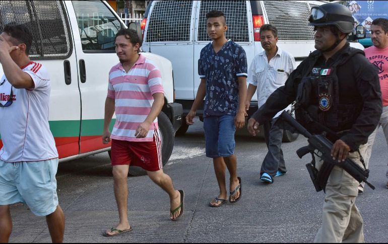 Agentes de la policía ministerial, apoyados por la Guardia Nacional, aseguran a 54 migrantes de nacionalidad centroamericana en Cancún. EFE/A. Cupul