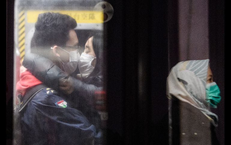 Un beso al transportarse por el metro de Hong Kong. AFP/A. Wallace