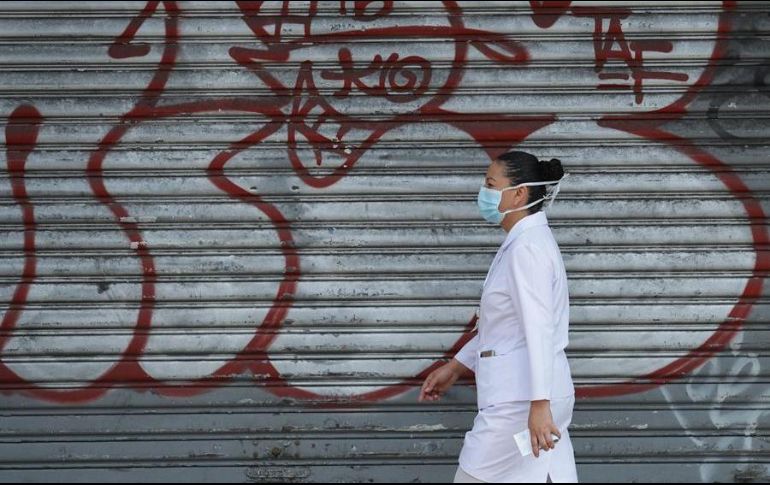 Una enfermera camina en una calle de San Salvador. EFE/R. Sura