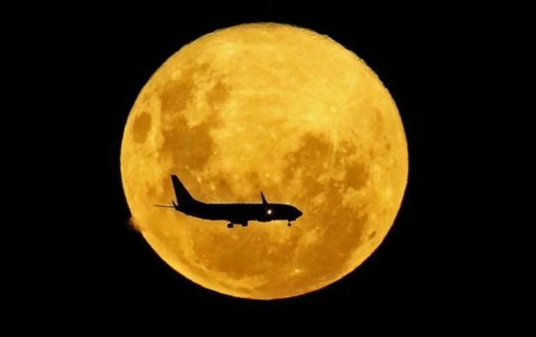 Un avión pasa por delante de la Luna, desde Curitiba, Brasil, el 9 de marzo de 2020. GETTY IMAGES