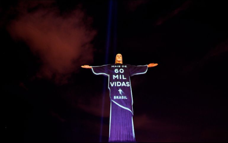 La estatua del Cristo Redentor en Río de Janeiro se ilumina en un homenaje a las personas fallecidas por COVID-19. AFP/M. Pimentel
