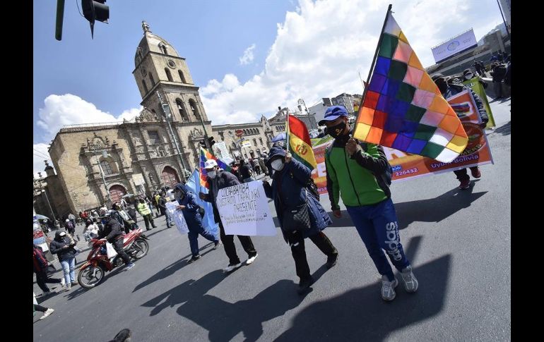 Docentes y organizaciones obreras muestran pancartas y ondean banderas este martes durante una protesta en La Paz. EFE