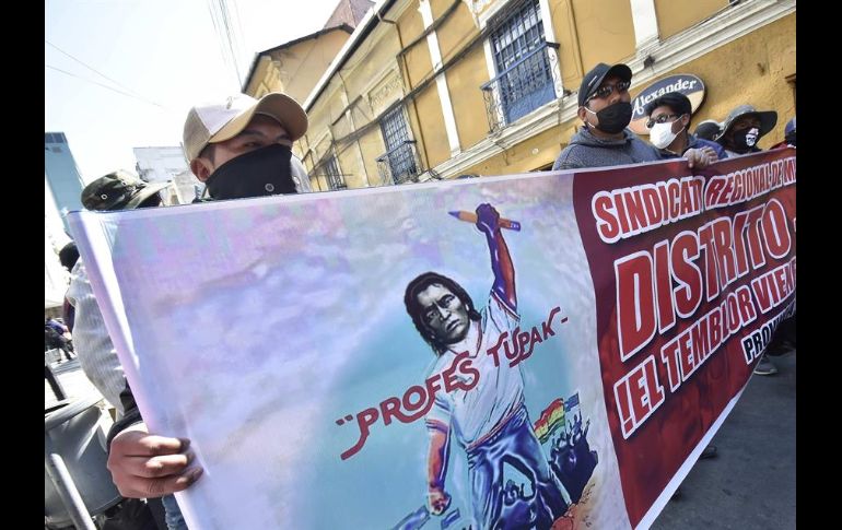 Docentes y organizaciones obreras muestran pancartas y ondean banderas este martes durante una protesta en La Paz. EFE