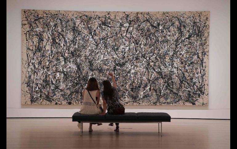 Con toda la calma del mundo, dos mujeres admiran la obra de Pollock sentadas en una banca. AFP / T. A. Clary