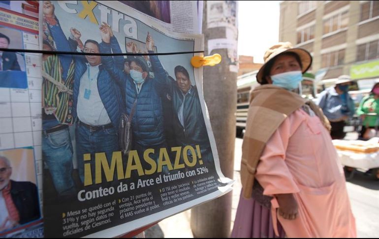 Una mujer pasa junto a un periódico con una foto del presidente electo Luis Arce celebrando su victoria, este martes, en La Paz. EFE/J. Alves
