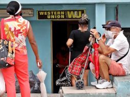 Varias personas esperan al frente de una oficina de Western Union, en La Habana. EFE/ARCHIVO