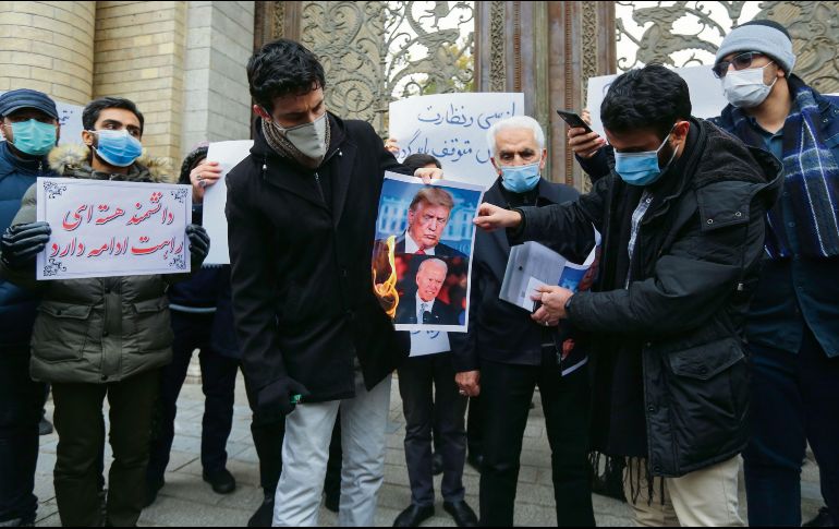 DESCONTENTO. Estudiantes queman las imágenes de Donald Trump y Joe Biden en la capital iraní. AFP