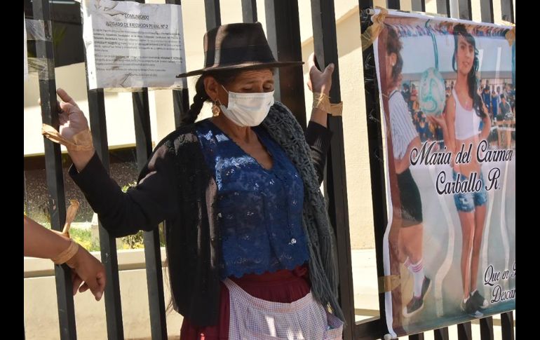 Pilar Reyes, una humilde mujer quechua, protesta atando sus manos con cinta adhesiva a la reja del Tribunal Departamental de Justicia de Cochabamba. EFE/J. Abrego