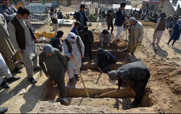 Familiares de niñas fallecidas en ataque cavan hoy tumbas para sepultarlas en el cementerio de Dasht-e-Barchi, a las afueras de Kabul. AFP/W. Kohsar