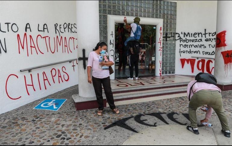 Varias personas pintan mensajes en el Palacio federal durante unas protestas hoy, en Acapulco, para exigir la liberación de los normalistas de Mactumatzá. EFE/D. Guzmán