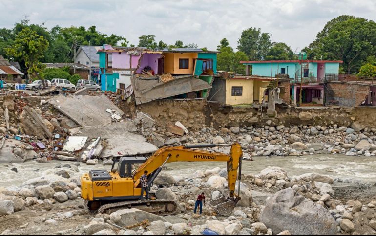 Autoridades locales utilizan maquinaria pesada para remover los restos de casas afectadas por los deslaves en Dharmsala, en India. AP/A. Bathia