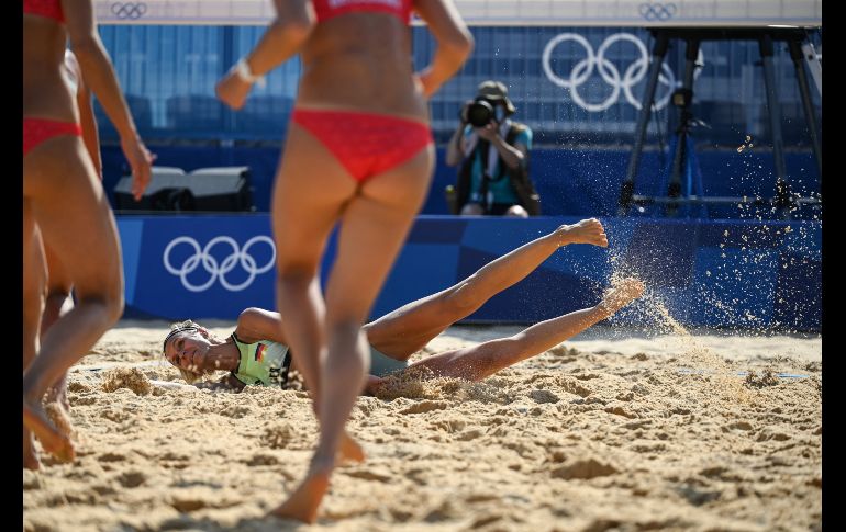 La alemana Laura Ludwig termina sobre la arena al intentar devolver una pelota en ronda preliminar de voleibol de playa ante el equipo de Suiza. AFP/A. Weiss