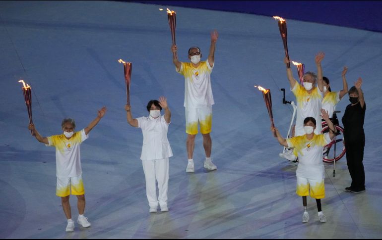 Ex atletas sostienen las antorchas paralímpicas durante la ceremonia de apertura. AP / E. Hoshiko