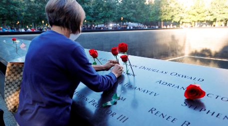 Una mujer coloca flores en el memorial de las víctimas del 11 de Septiembre en Nueva York a 20 años de ataque terrorista. EFE / M. Segar