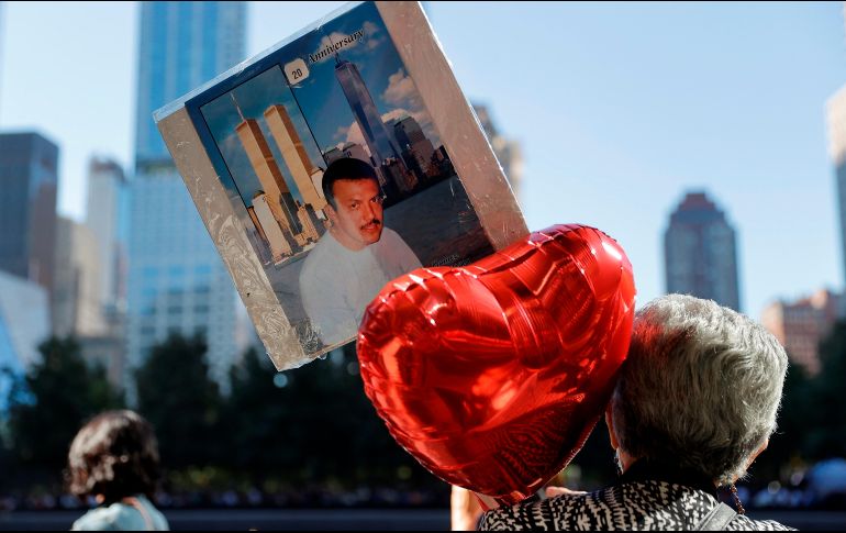 Una persona sostiene un globo en forma de corazón y una fotografía de una de las víctimas del atentado contra las Torres Gemelas de Nueva York, a 20 años del ataque terrorista. EFE / M. Segar
