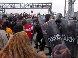Familiares de presos forcejean con policías afuera del penal de Apodaca luego de darse a conocer la riña. EFE/G. Pérez