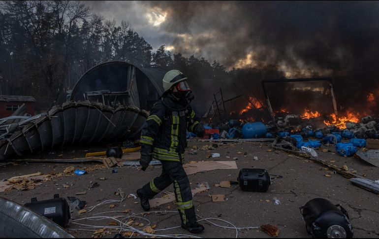 En diferentes partes de Ucrania se intenta aminorar el daño de los bombardeos, como este bombero apagando el fuego de una bodega destrozada. EFE / R. Pilipey