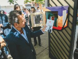 El alcalde de Guadalajara, Pablo Lemus Navarro, observó los títulos incluidos en uno de los buzones literarios instalados en el Paseo Alcalde. EL INFORMADOR/ G. Gallo