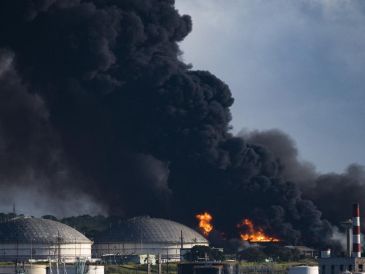 Fuertes llamas y una alta columna de humo negro se alzan en la base de supertanqueros, en el cinturón industrial de la ciudad de Matanzas. AFP / Y. Lage
