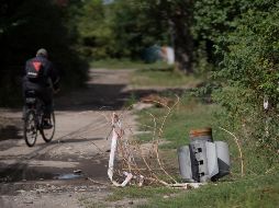 Un hombre pasea a bordo de su bicicleta cerca de los retos de un cohete en Sloviansk, Ucrania. AP/L. Correa