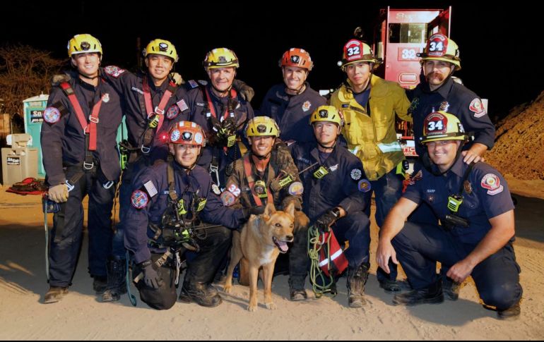 El orgulloso equipo de rescate posa con el perrito, que no presentó lesiones tras el accidente. AP/Departamento de Bomberos de Pasadena