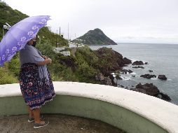 Una mujer mira al mar en Mazatlán, tras el impacto de 
