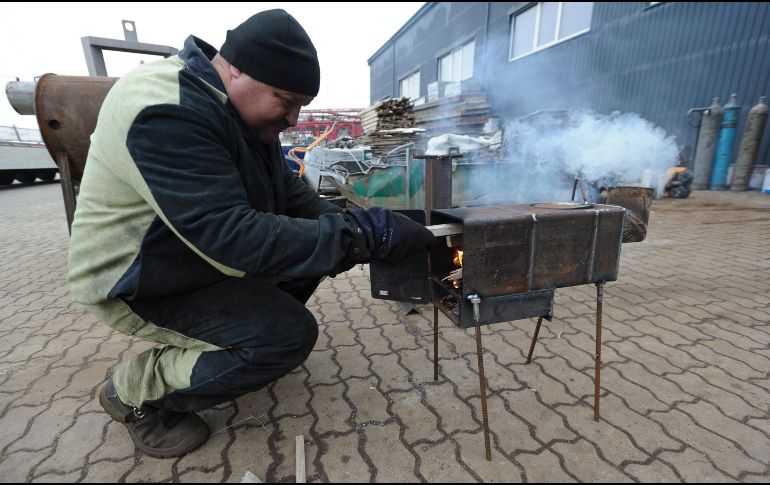 Un trabajador prueba el funcionamiento de estufas de metal hechas a mano destinadas a militares ucranianos y desplazados internos del este del país, en una fábrica en los suburbios de Lviv. EFE/M. Tys