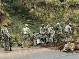 Un grupo de miembros de las fuerzas militares trabajan en el desbloqueo de una vía que une la localidad de Laraqueri con la ciudad de Puno. EFE