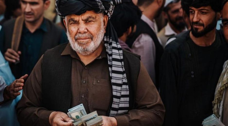 Un cambista ofrece dólares en un mercado de Kabul. GETTY IMAGES