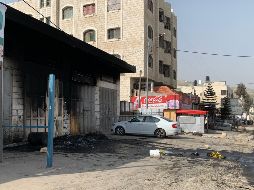 Vista de edificios, coches y negocios palestinos calcinados en el pueblo palestino de Huwara este lunes tras el asalto anoche de unos 400 colonos. EFE/P. Duer