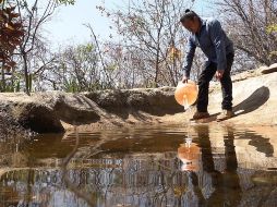 El ambientalista Carlos Alberto Morales vierte agua en un oasis el 21 de marzo de 2023, en el estado de Oaxaca. EFE/J. Méndez