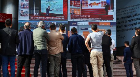 Varios turcos observan en pantallas el conteo de los votos en tiempo real de las elecciones. EFE/S. Suna
