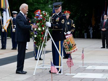 Joe Biden contempló la corona de flores, adornada con un moño de color rojo, blanco y azul, luego bajó la cabeza y comenzó a orar. AP/S. Walsh