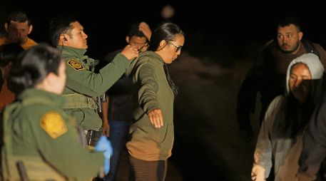 La Patrulla Fronteriza de Estados Unidos revisa a una migrante cerca de la valla fronteriza entre Estados Unidos y México. AFP