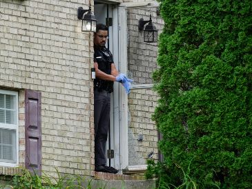 Un miembro del Departamento de Policía de Florence, Kentucky, frente a la puerta de una casa que fue escenario de un tiroteo, el sábado 6 de julio de 2024, en Florence, Kentucky. (AP Foto/Carolyn Kaster)