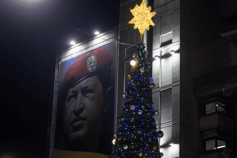 Fotografía de un cartel con la imagen del fallecido expresidente Hugo Chávez junto a un árbol de Navidad. EFE/M.  Gutiérrez.