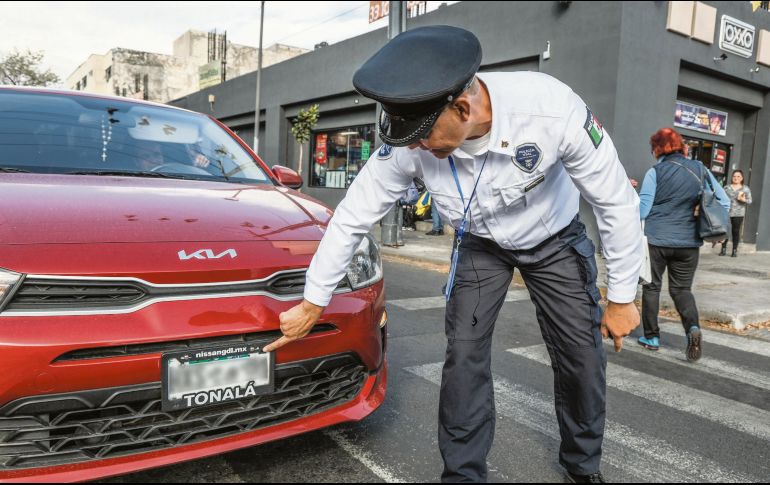 Oficial de la Policía Vial muestra el código QR que no debe ser tapado por el portaplacas. EL INFORMADOR/A. Navarro