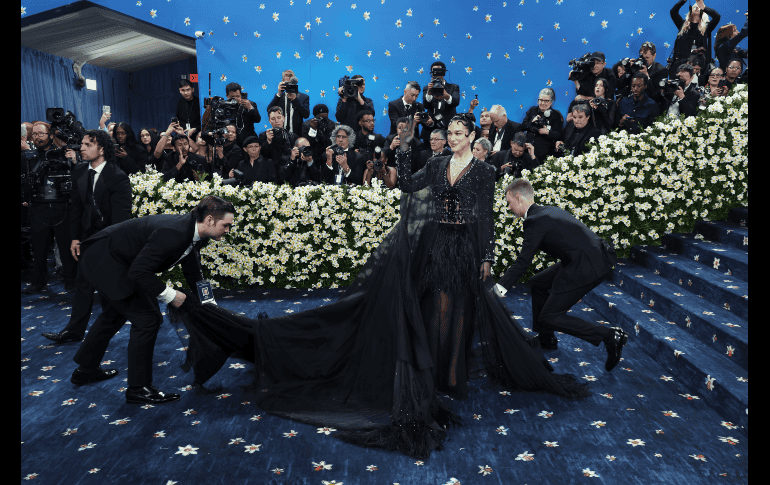 Dua Lipa comenzó su fashion perfomance con una extensa capa traslúcida decorada por plumas suaves en el bajo de color negro. EFE/J. Lane.