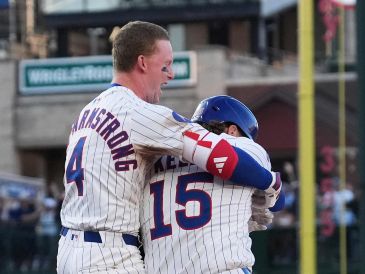 Kelly (derecha) celbra con Crow-Armstrong (izquierda) el sencillo productor de la carrera de la victoria. AP/N. Huh