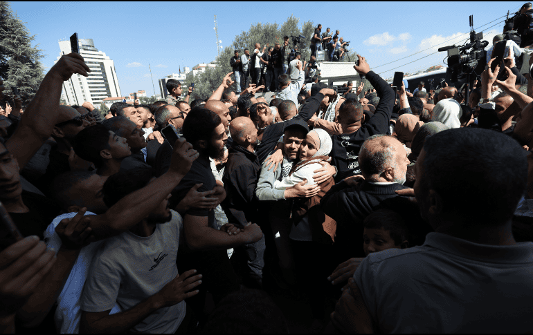 La gente saluda a los presos palestinos liberados a su llegada tras ser puestos en libertad como parte del acuerdo de liberación entre Israel y Hamás, en la ciudad cisjordana de Ramala. EFE / A. Badarneh